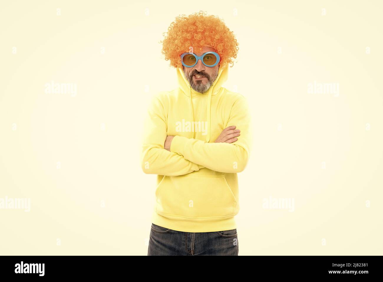 Lustiger Mann trägt orangene Perücke mit geeky Look halten die Arme gekreuzt, extravagant Stockfoto