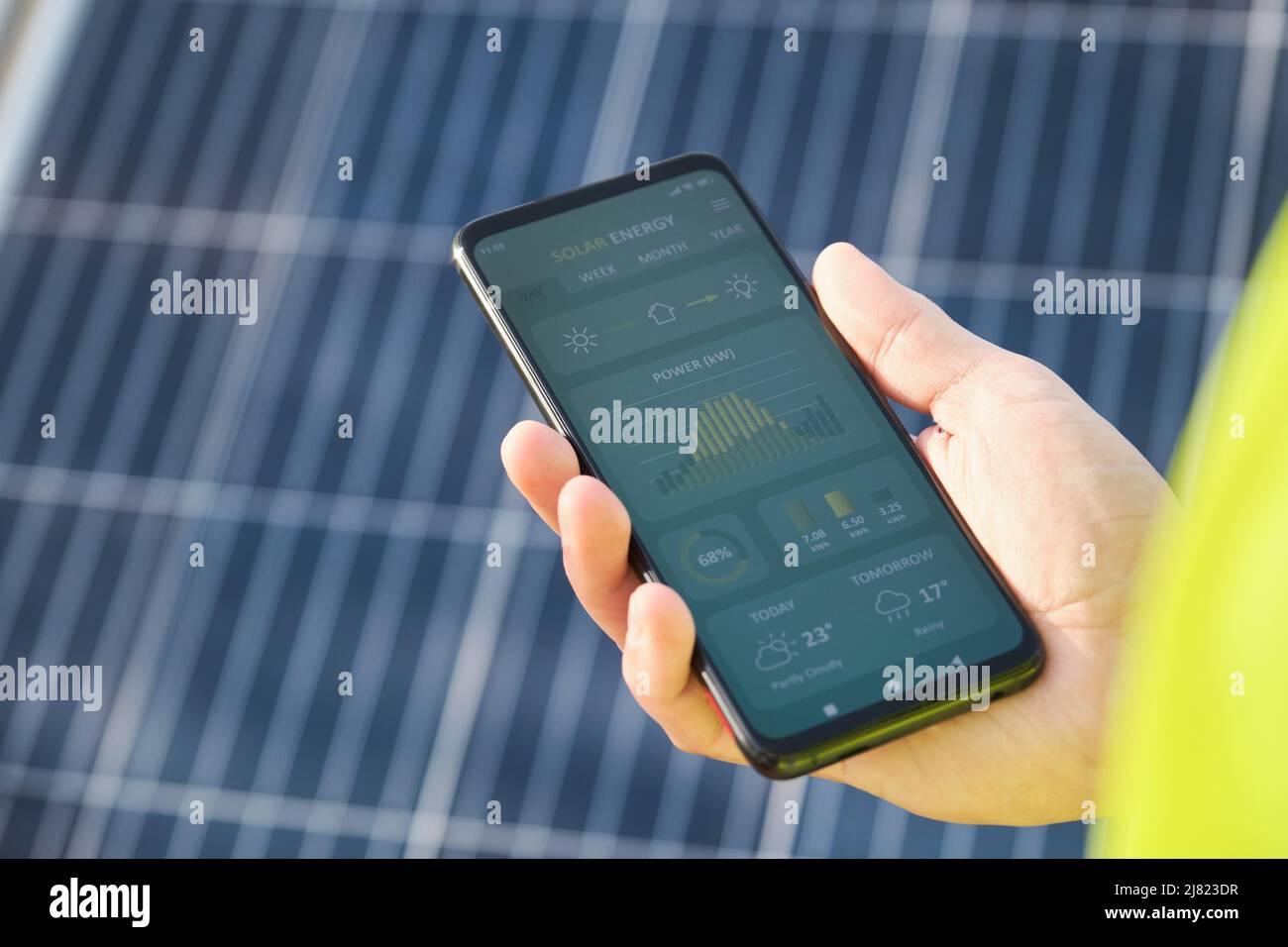 Hand zeigt eine Smartphone-App zur Solarstromerzeugung. Stockfoto