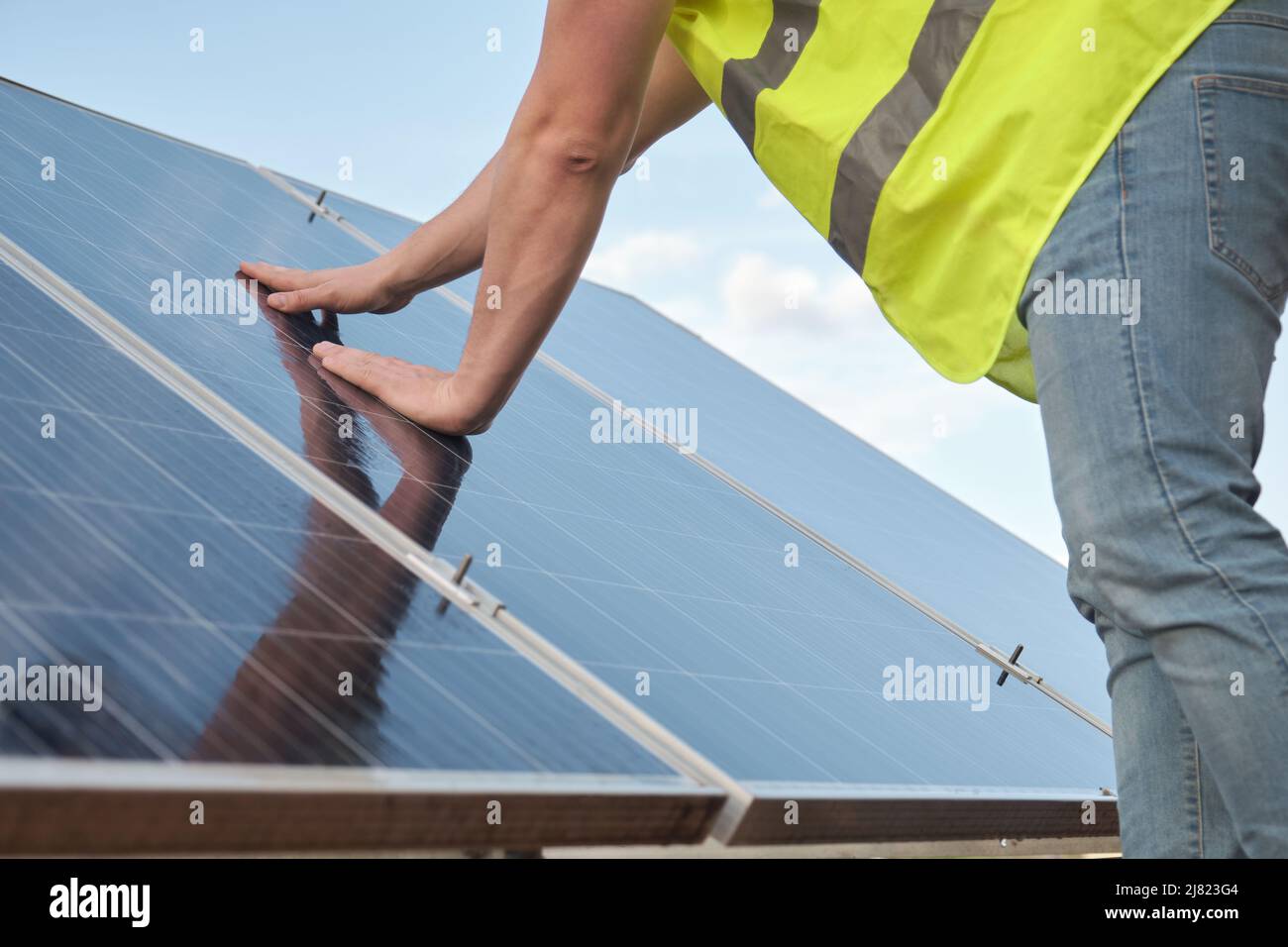 Nahaufnahme eines Ingenieurs, der die Funktion und Sauberkeit der Photovoltaikanlage überprüft. Stockfoto