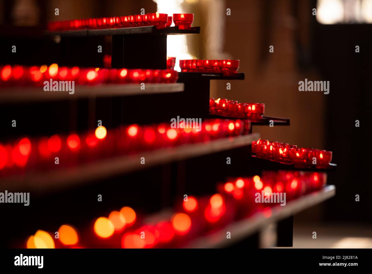 Votivkerzen flackern in den Entwürfen an der Vorderseite der St. Bartholomäus-Kirche in Frankfurt am Main Stockfoto