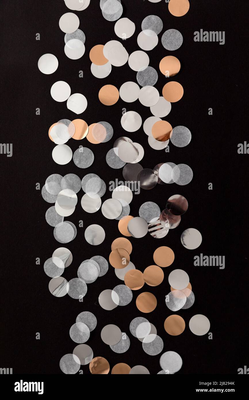 Silberne, goldene, weiße Konfetti-Punkte auf schwarzem Hintergrund. Glitzer-Konfetti-Hintergrund Stockfoto