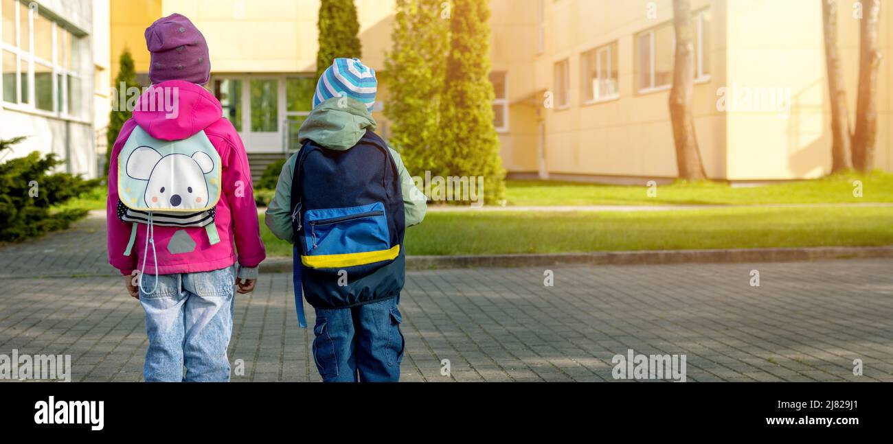 Grundschulbildung - Schüler mit Rucksäcken gehen morgens zur Schule. Platz kopieren Stockfoto