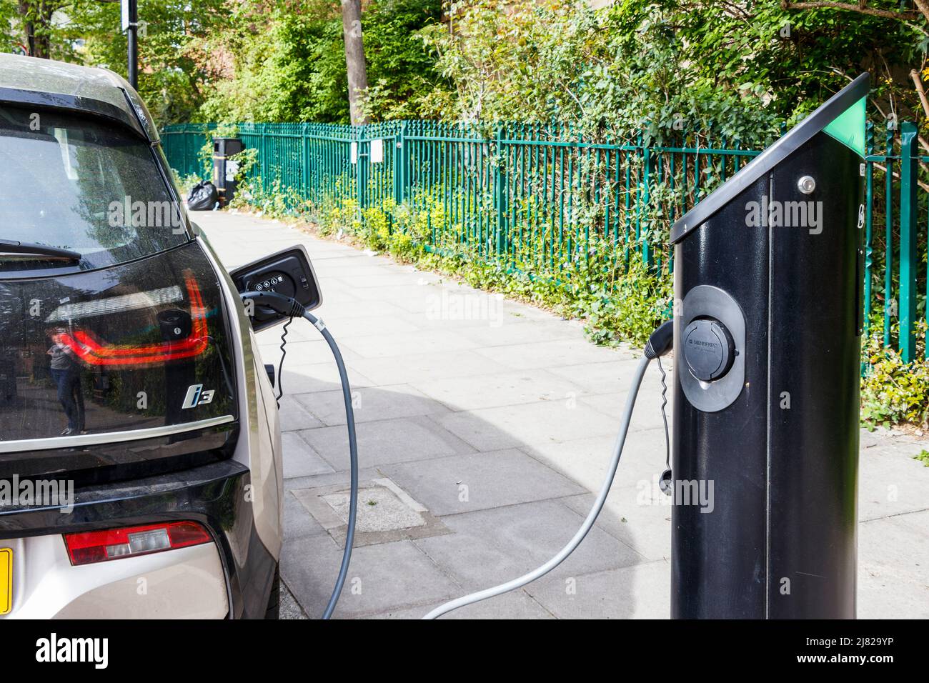 Ein Elektrofahrzeug, das an einer Ladestation am Straßenrand, London, Großbritannien, aufgeladen wird Stockfoto