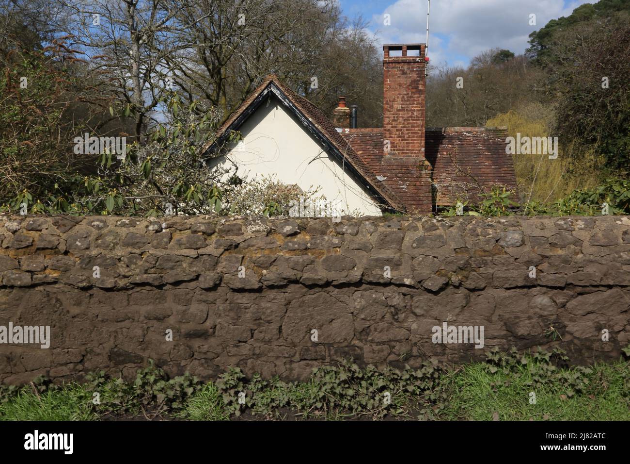 Friday Street Surrey England Pond Cottage und Stone Wall Stockfoto