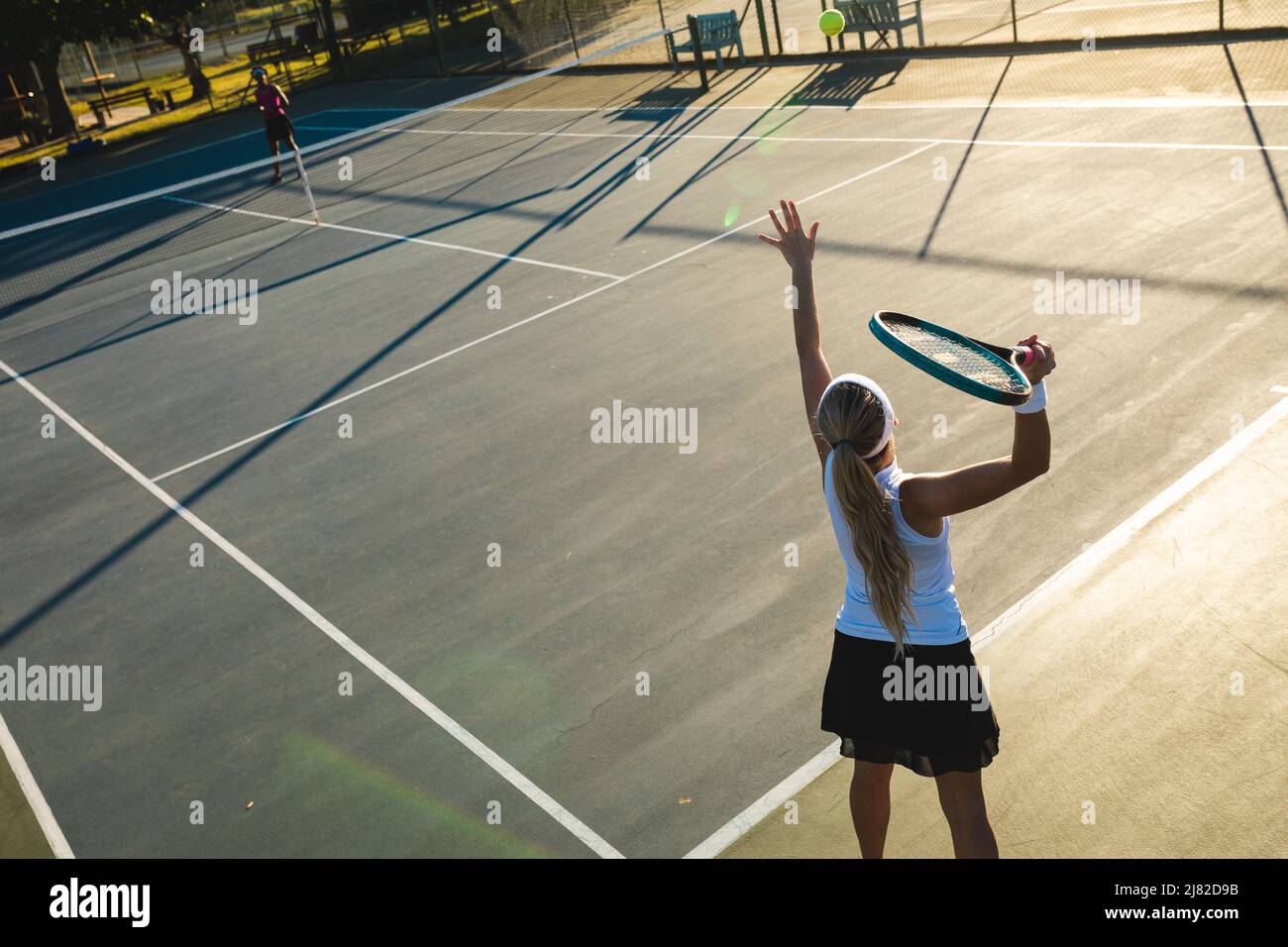 Blick aus der Perspektive auf die junge kaukasische Spielerin, die während eines Tennisspiels auf dem Platz spielt Stockfoto