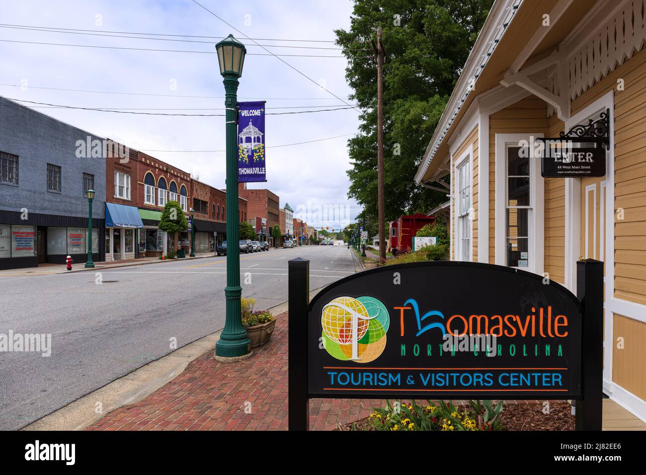 THOMASVILLE, NC, USA-8 MAY 2022: Thomasville Tourism & Visitors Center, mehrere Schilder, rote Kaboose, Blick auf die Main Street. Stockfoto