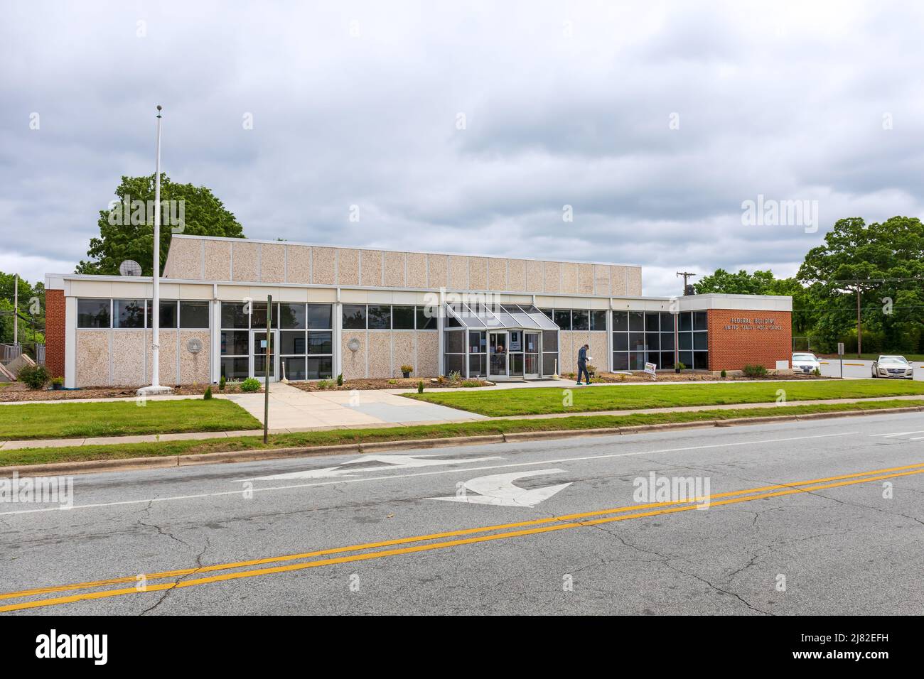 THOMASVILLE, NC, USA-8. MAI 2022: Thomasville Post Office. Zwei Personen verlassen das Gebäude. Stockfoto