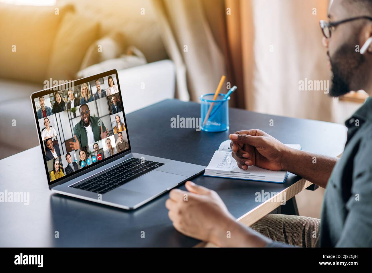 Online-Business-Briefing. Männliche afroamerikanische Angestellte sprechen auf Videoanruf mit verschiedenen multirassischen Kollegen, auf Laptop Bildschirm verschiedene Geschäftsleute, Treffen online, Gruppe Brainstorming Stockfoto