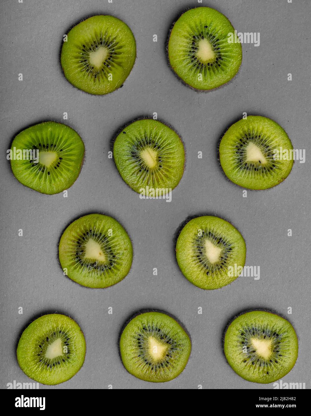 Draufsicht auf Kiwi-Scheiben auf grauem Hintergrund Stockfoto