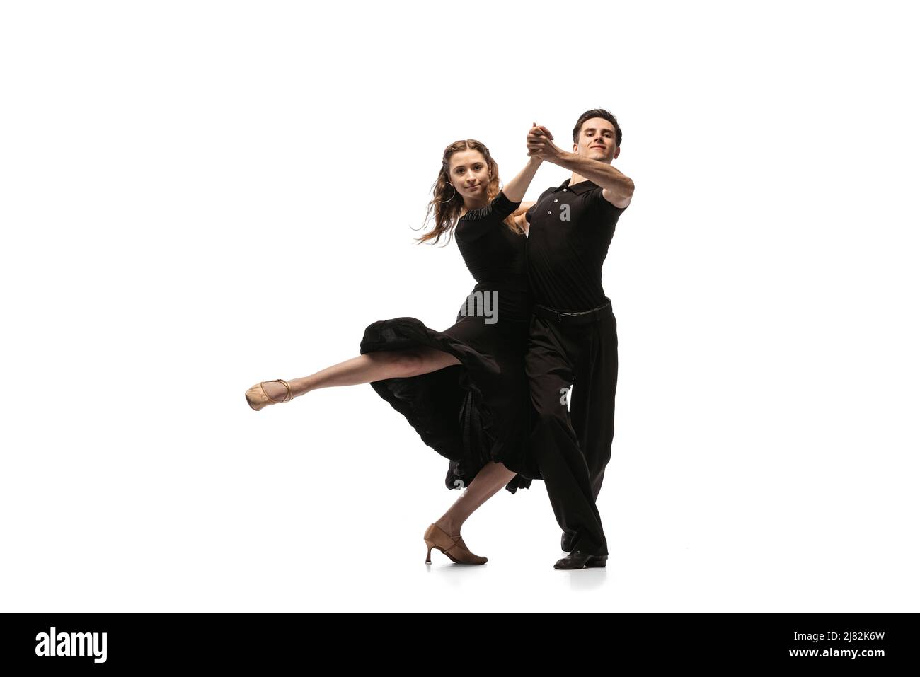 Portrait von jungen anmutigen Tänzern in schwarzen Bühnenoutfits tanzen Ballsaal Tanz isoliert auf weißem Hintergrund. Konzept von Kunst, Schönheit, Musik Stockfoto