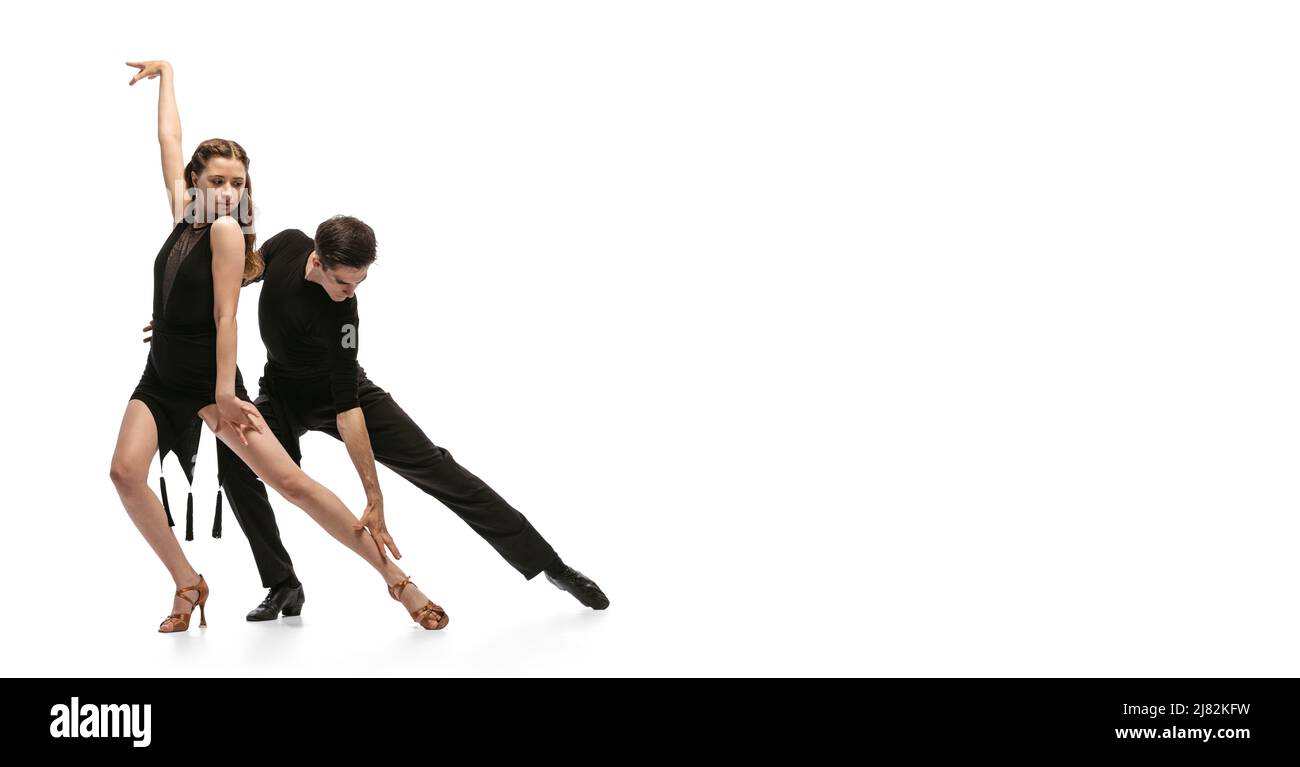 Anmut. Dynamisches Porträt von jungen, gefühlvollen Tänzern in schwarzen Outfits, die auf weißem Hintergrund den Tanz im Ballsaal tanzen. Konzept von Kunst, Schönheit, Musik Stockfoto