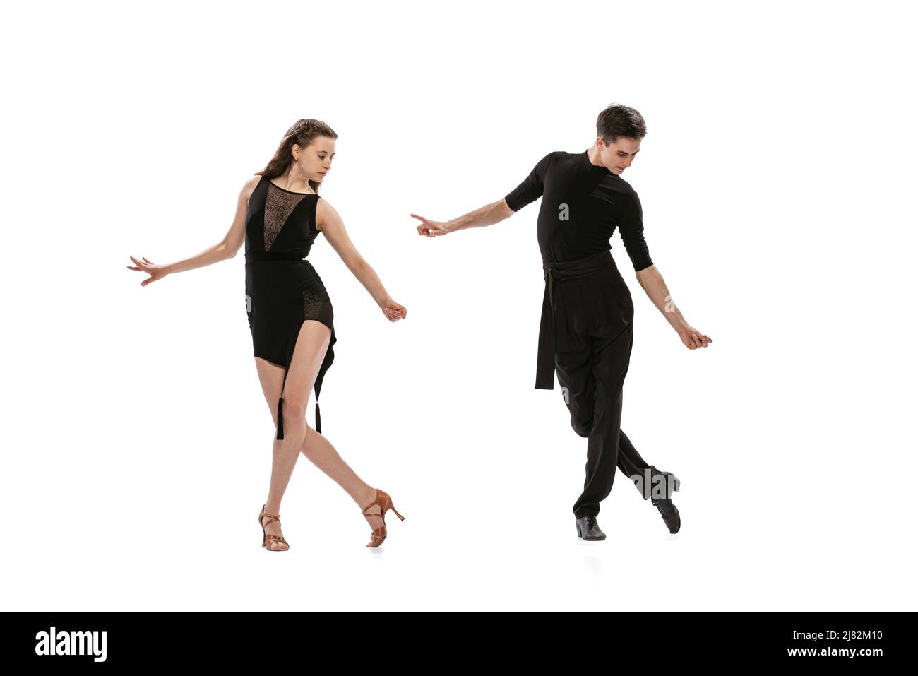 Quickstep. Dynamisches Porträt von jungen, gefühlvollen Tänzern in schwarzen Outfits, die auf weißem Hintergrund den Tanz im Ballsaal tanzen. Konzept von Kunst, Schönheit Stockfoto