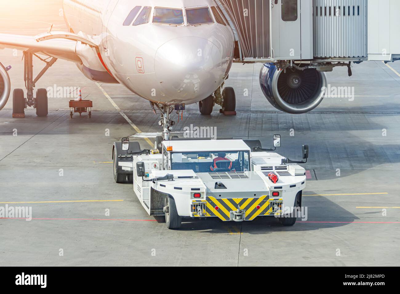Abschleppwagen, der sich bereit zum Abschleppen des Flugzeugs zum Parkplatz am Flughafen befindet Stockfoto