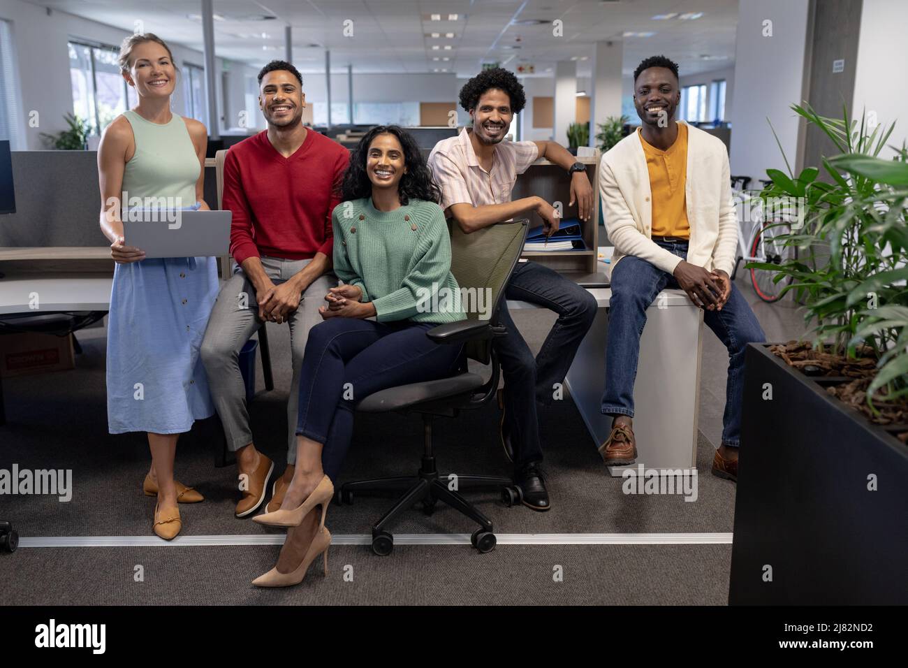 In voller Länge Porträt von lächelnden, multirassischen Beratern an modernen Arbeitsplätzen Stockfoto