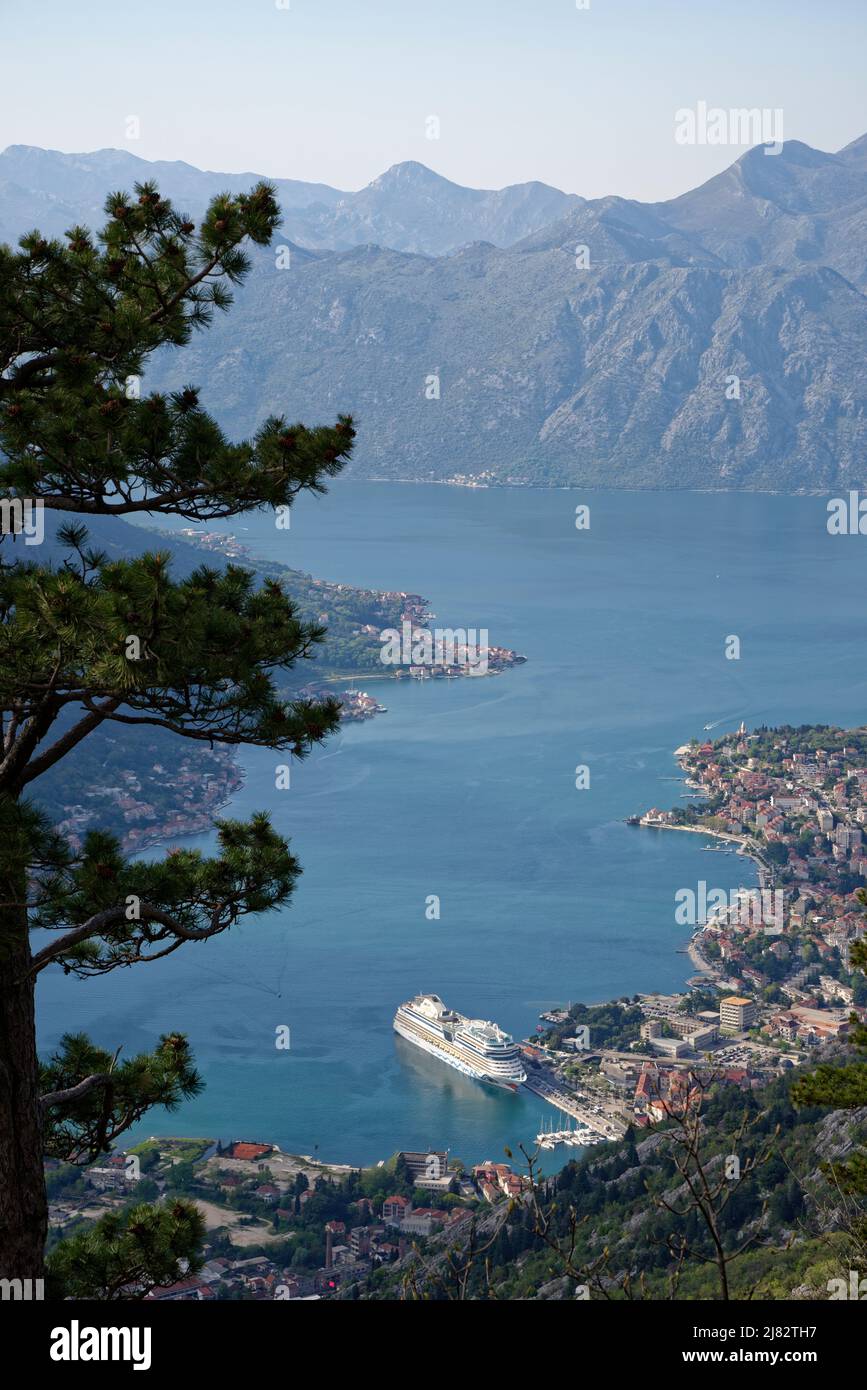 Blick auf die Bucht von Kotor, Montenegro. Kreuzfahrtschiff in Kotor. Dörfer und die Stadt Kotor am Rande des Meeres mit dramatischen umliegenden Bergen. Stockfoto