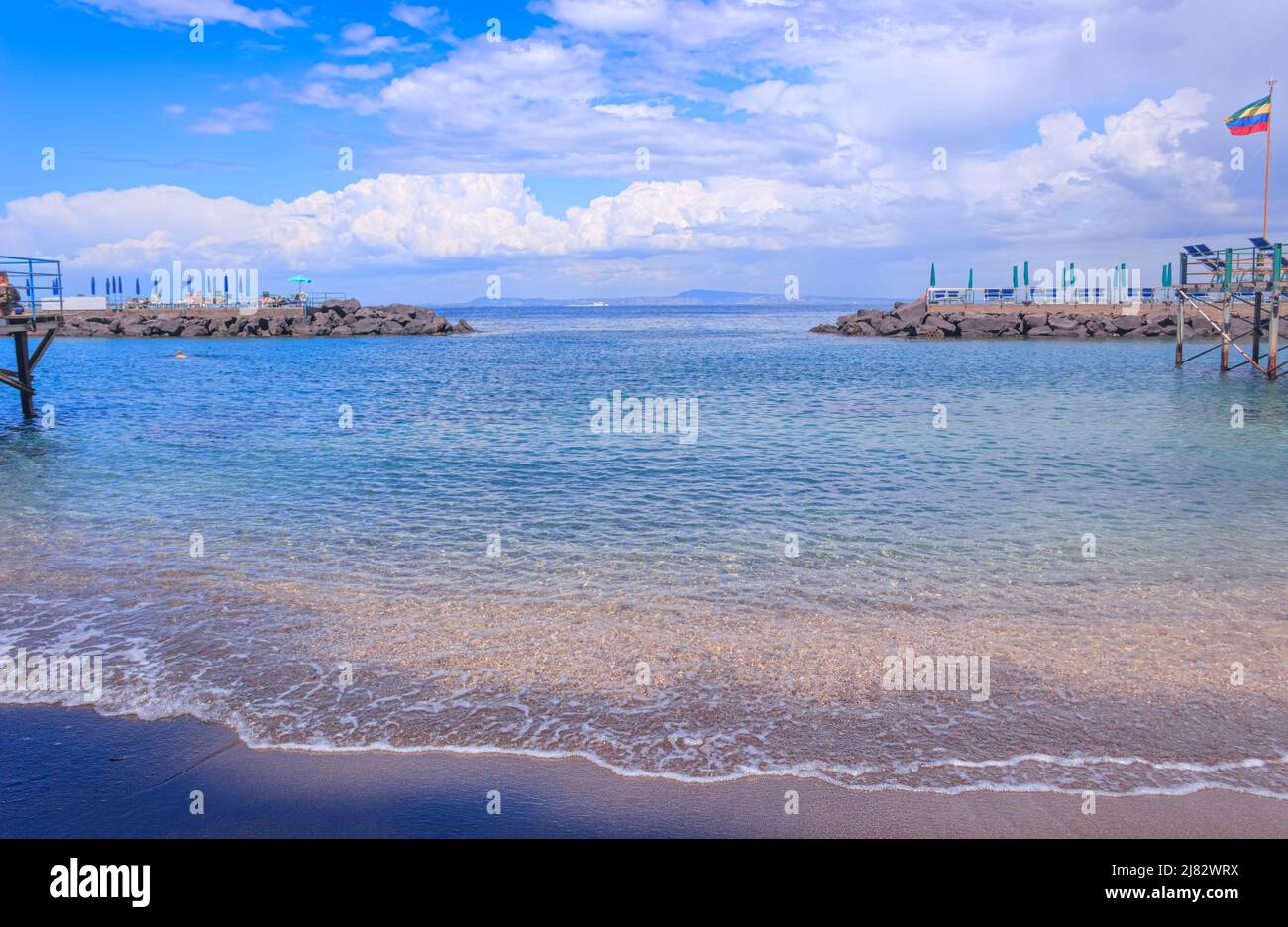 Sommer: Sorrento Strand in Italien. Blick auf die mit Strandhütten und Sonnenschirmen gesäumten Stege am Meer. Stockfoto