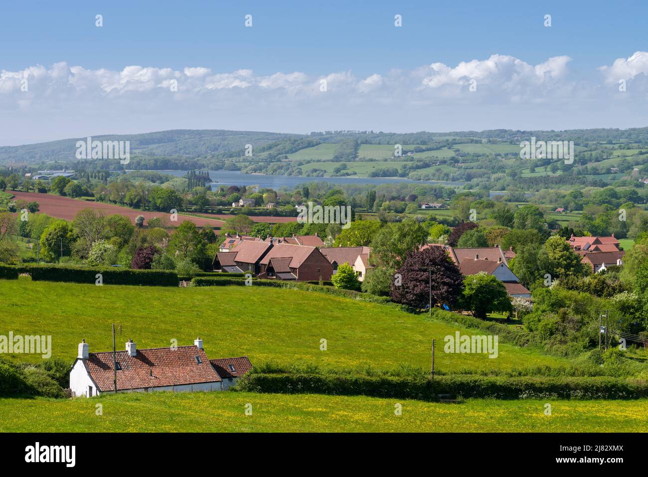 Das Dorf Compton Martin am Fuße der Mendip Hills im Chew Valley mit dem Blagdon Lake Reservoir in der Ferne, Somerset, England. Stockfoto