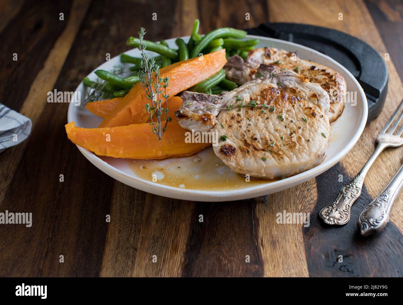 Fitness-Abendessen oder Mittagessen mit gebratenem Schweinekotelett, Süßkartoffeln und grünen Bohnen auf einem Teller Stockfoto