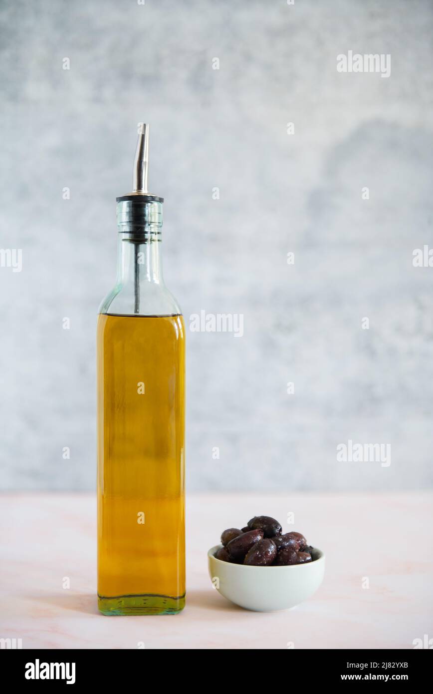 Olivenöl-Dekanter mit einer kleinen Schale Oliven Stockfoto