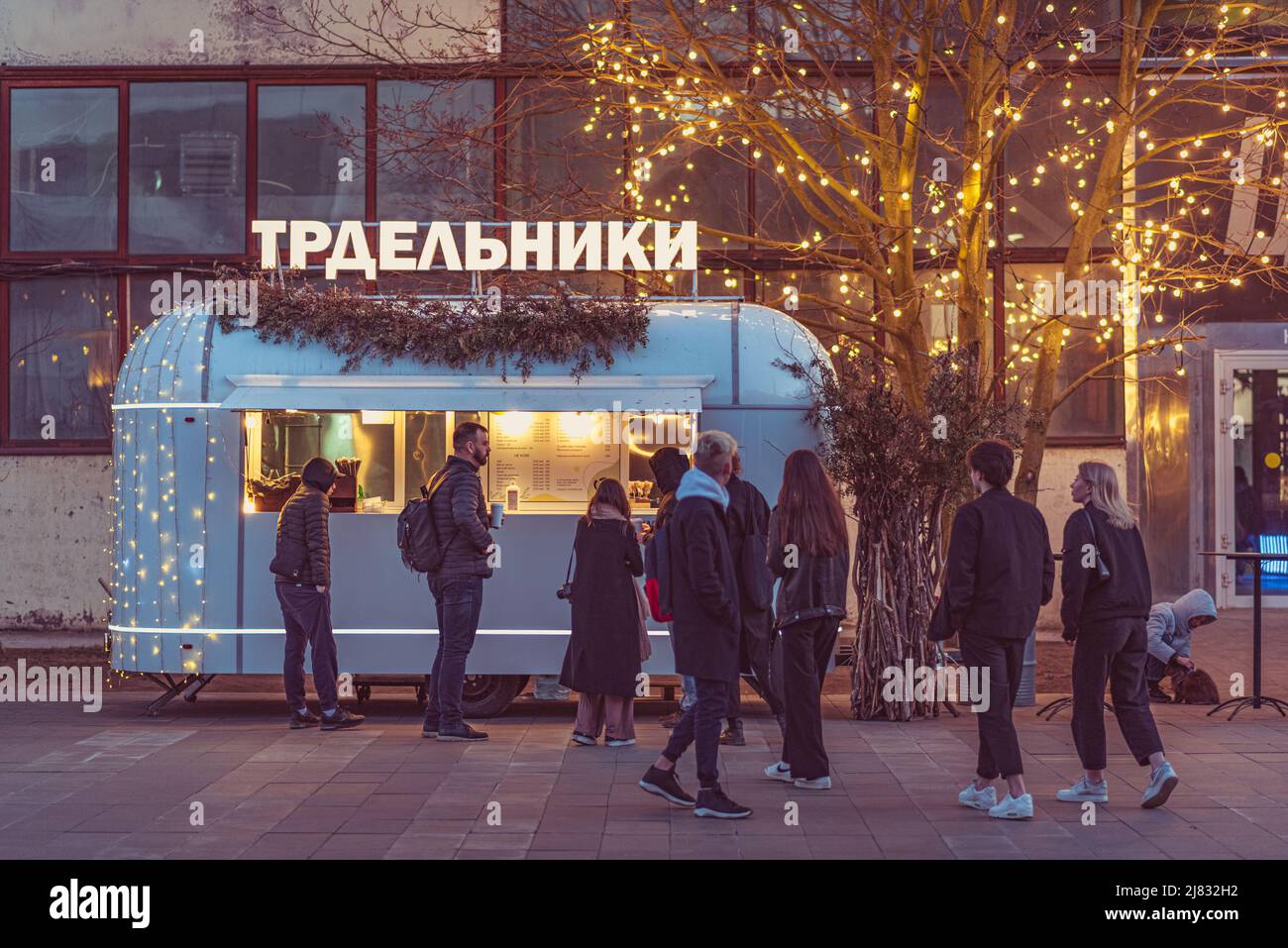 Sankt Petersburg, Russland: Die Leute stehen in der Schlange vor einem Food-Truck, der Trdelniks verkauft (auf dem Schild des Ladens auf Russisch geschrieben), im Hafen von Sevkabel. Stockfoto