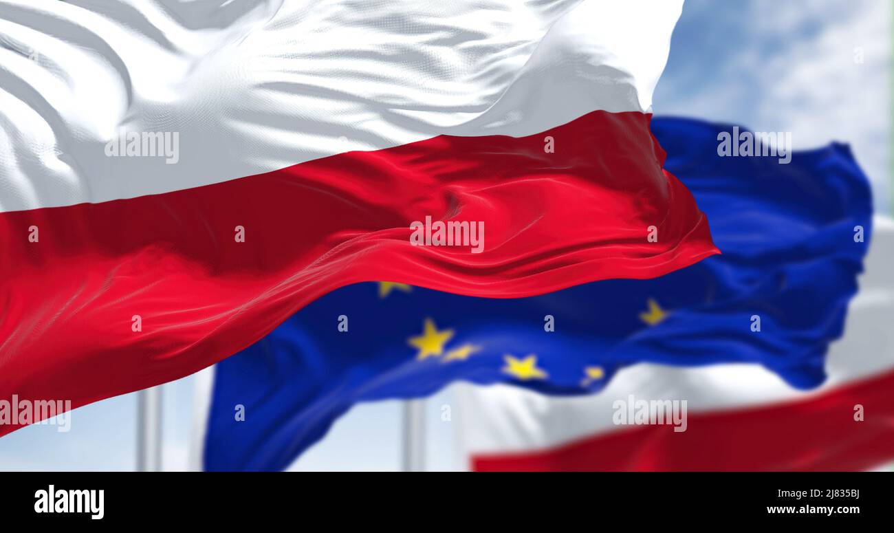 Detail der im Wind winkenden Nationalflagge Polens mit verschwommener eu-Flagge im Hintergrund an einem klaren Tag. Demokratie und Politik. Eu Stockfoto