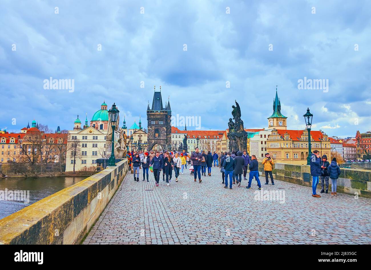 PRAG, TSCHECHISCHE REPUBLIK - 5. MÄRZ 2022: Die mittelalterliche Stein-Karlsbrücke mit historischen Skulpturen und Altstädter Brückenturm im Hintergrund, am März Stockfoto