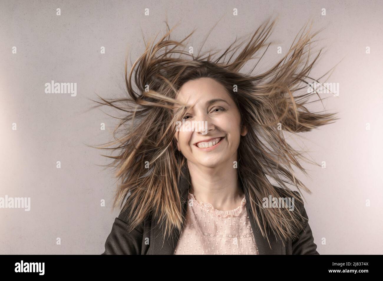 Porträt einer Frau mit im Wind wehenden Haaren, glücklicher Ausdruck Stockfoto