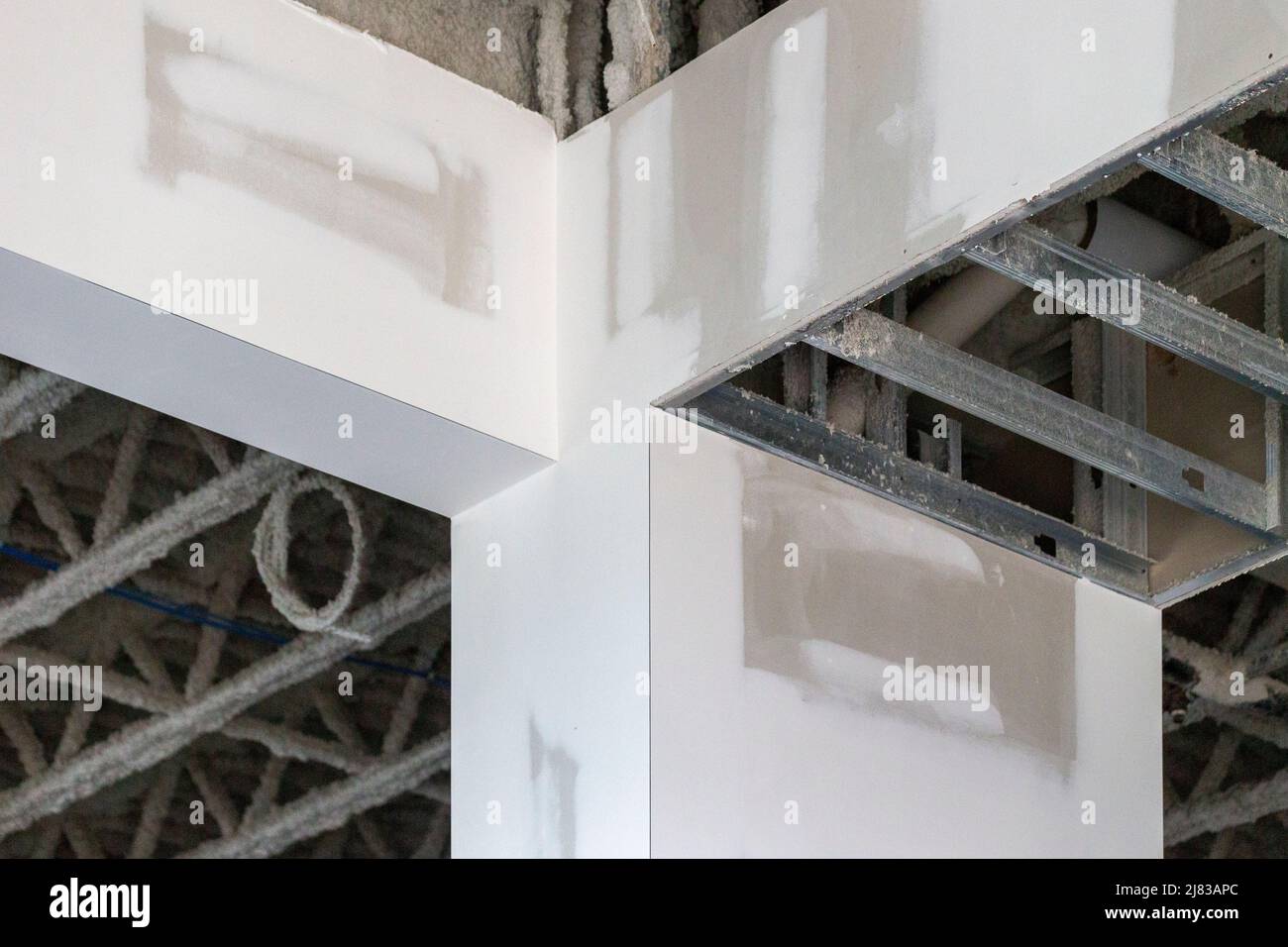 Stützsäule mit verzinkten Stahlrahmenarmen, die teilweise trocken und verputzt sind. Stockfoto