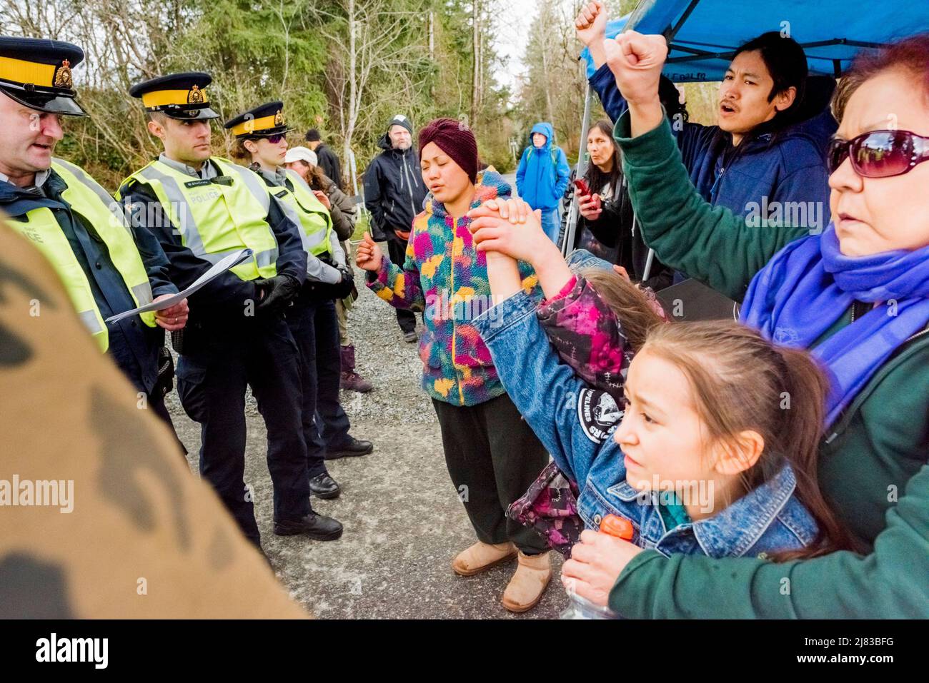 Indigene Pipeline-Demonstranten, darunter eine Großmutter und kleine Kinder, werden als Unterlassungsverfügung vorgelesen, da sie einen Lastwagen vom Eingang zum Trans Mountain Pi blockieren Stockfoto