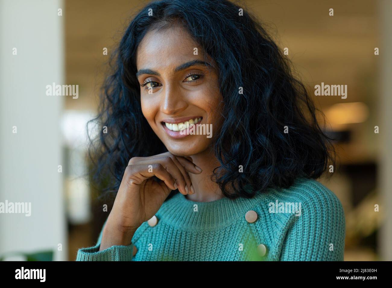 Porträt einer lächelnden, schönen jungen Biracial-Frauenberaterin mit schwarzem Haar am Arbeitsplatz Stockfoto