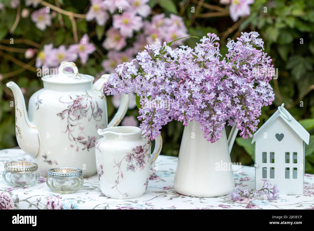 Romantische Dekoration mit Blumenstrauß aus Flieder und Vintage-Porzellan Stockfoto