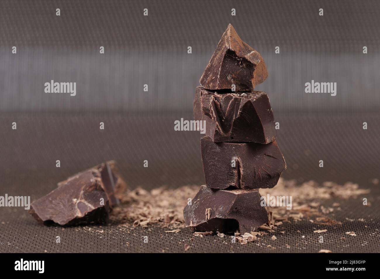 Zerbrochene dunkle Schokolade und Kakaopulver auf einem Tisch Stockfoto
