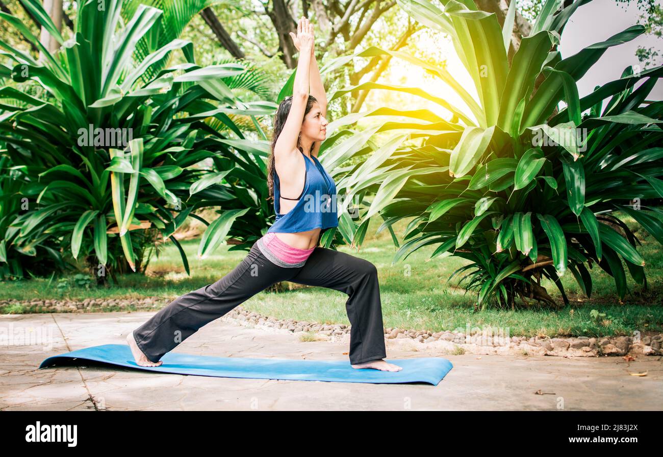 Frau, die im Freien Yoga macht, Ein Mädchen, das Flexibilitätsyogas durchführt, junges Mädchen, das im Freien Yoga-Stile zeigt, Yoga und Fitnesskonzept Stockfoto