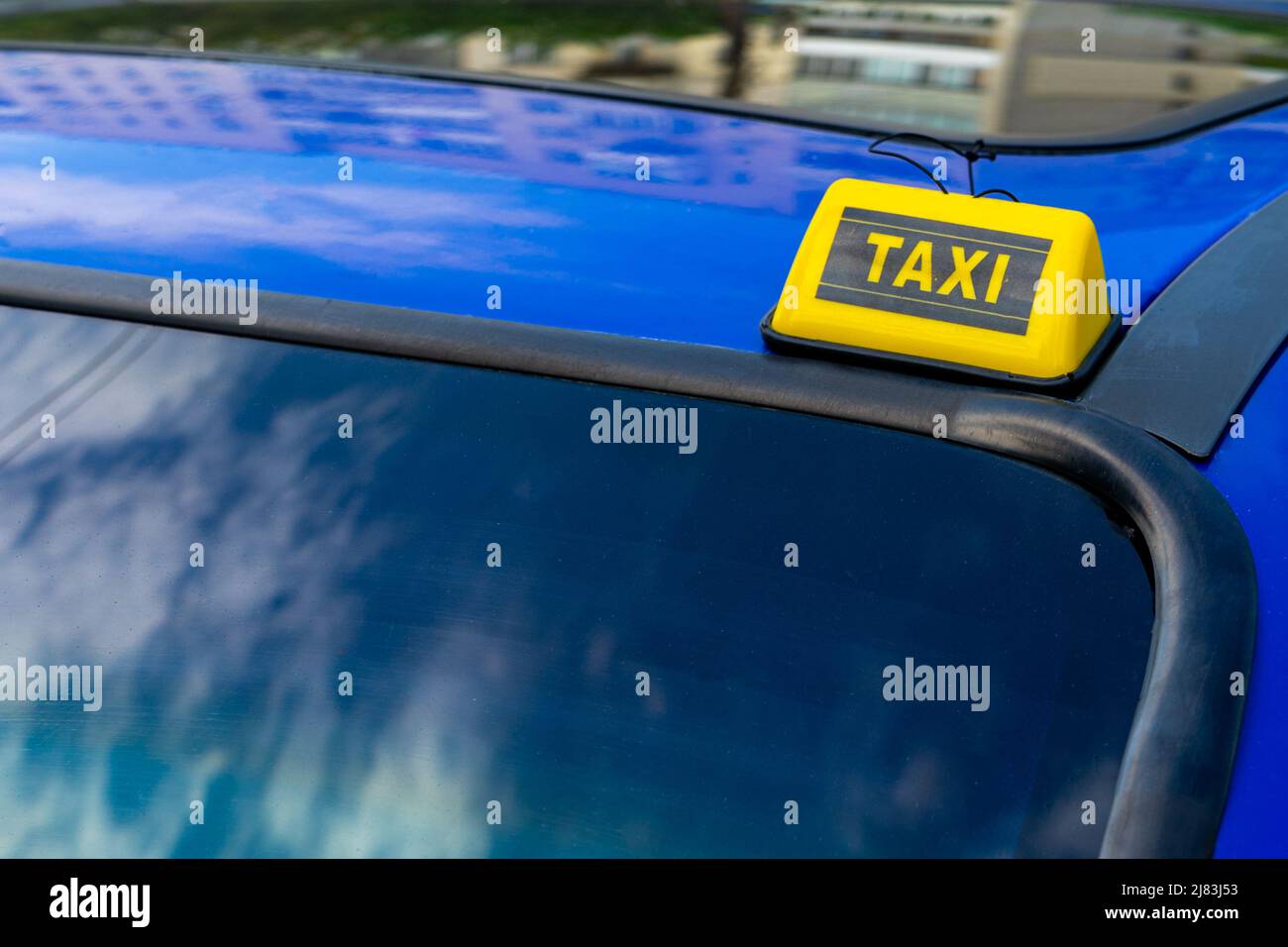 Yellow Chip Taxi auf dem Dach eines blauen Autos. Stockfoto