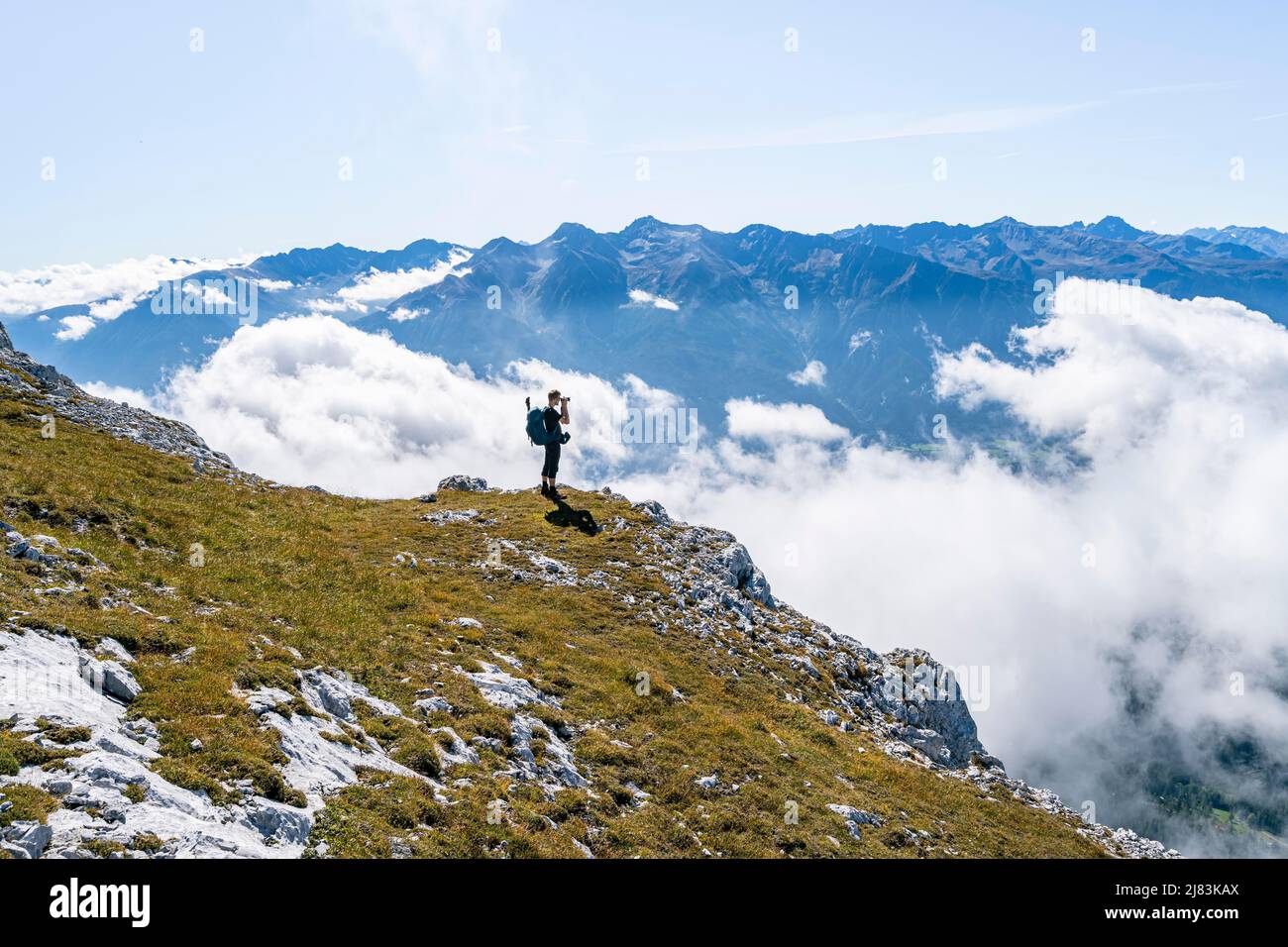 Wanderer über den Wolken, fotografiert, Sellrainer Berge im Hintergrund, Wanderweg über hohe Munde, Mieminger Kette, Tirol, Österreich Stockfoto