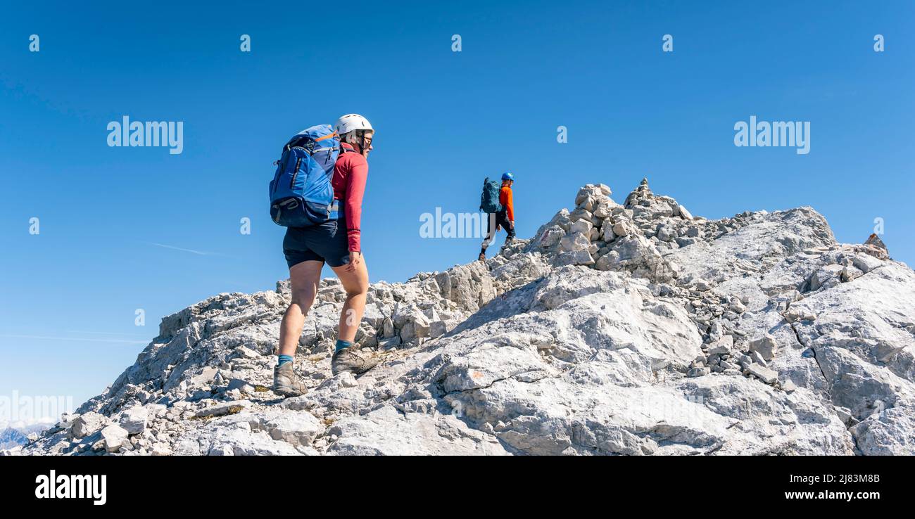 Wanderer mit Kletterhelm auf einem steilen Felskamm, Höhenwanderung, hohe Munde, Mieminger Gebirge, Tirol, Österreich Stockfoto