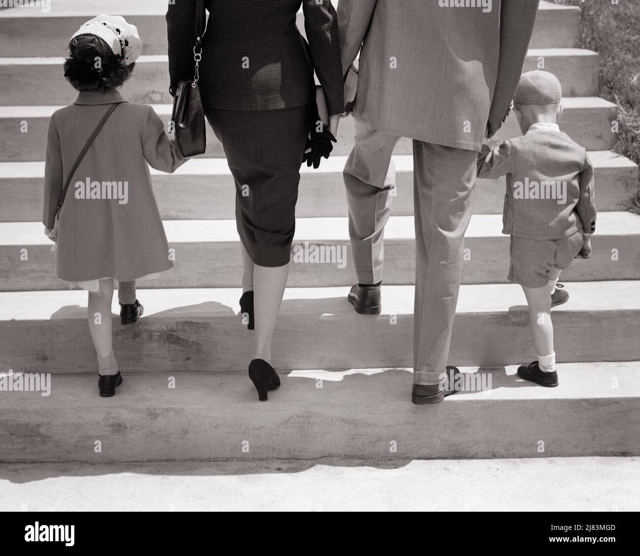 1940S 1950S RÜCKANSICHT DER FAMILIE, DIE ZUSAMMEN DIE TREPPE HOCHGEHT UND DIE HÄNDE HÄLT MUTTER VATER UND TOCHTER UND SOHN - J2429 HAR001 HARS DAD FOUR TRAINING MAMA KLEIDUNG KLETTERN NOSTALGISCHE ACTIVE PAIR 4 URBANE MÜTTER ALTE ZEIT ZUKUNFT NOSTALGIE ALTE MODE 1 TREPPEN FITNESS JUGENDLICH STIL GESUNDE JUNGE ERWACHSENE BESTEN SÖHNE FAMILIEN LEBENSSTIL RELIGION FRAUEN OSTERN VERHEIRATET SONNTAG EHEGATTEN EHEMÄNNER KOPIE RAUM HALBLANG DAMEN TÖCHTER PERSONEN MÄNNER VÄTER S&W PARTNER AKTIVITÄT KÖRPERLICHE STÄRKE STILE UND VÄTER NIEDRIGEN WINKEL RICHTUNG NACH OBEN KONZEPTUELL FLEXIBILITÄT MUSKELN STILVOLLE MODE JUGENDLICHE MÜTTER ZWEISAMKEIT Stockfoto