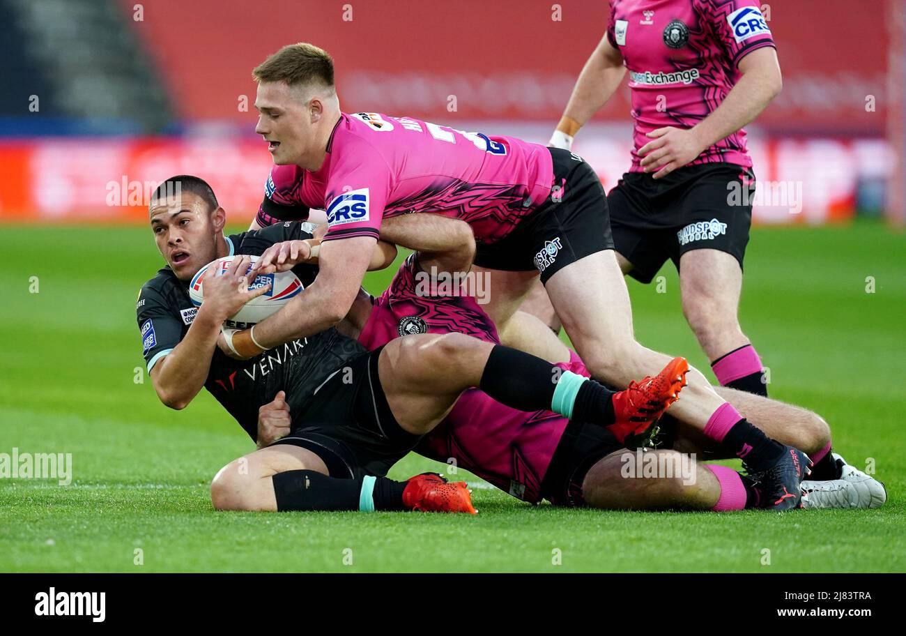 Die Tuimoala Lolohea von Huddersfield Giants wurde von Iain Thornley (Mitte) von Wigan Warriors und Sam Halsall während des Matches der Betfred Super League im John Smith's Stadium, Huddersfield, angegangen. Bilddatum: Donnerstag, 1212. Mai 2022. Stockfoto
