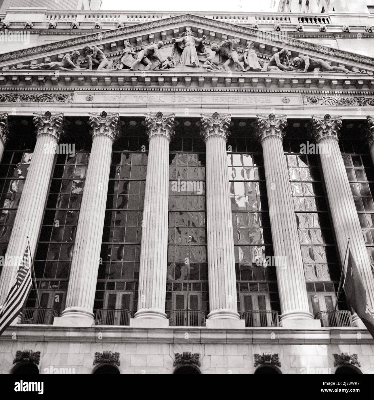 1970S KLASSISCHE REVIVAL-FASSADE DER NEW YORKER BÖRSE, ERBAUT 1903 IN DER BROAD STREET IN LOWER MANHATTAN, NEW YORK CITY USA - R24508 HAR001 HARS AUSSEN NIEDRIG WINKEL MÄCHTIG BREIT IN DER AUF GELEGENHEIT DIE SÄULEN NYC PEDIMENT KONZEPT KONZEPTUELLE NEW YORKER STÄDTE NYSE NEW YORK CITY KORINTHISCHE WIEDERBELEBUNG SYMBOLISCHE KLASSISCHE WIEDERBELEBUNG KONZEPTE FASSADE SCHWARZ-WEISSEN FINANZDISTRIKT HAR001 LOWER MANHATTAN ALTMODISCHE DARSTELLUNG BÖRSE Stockfoto