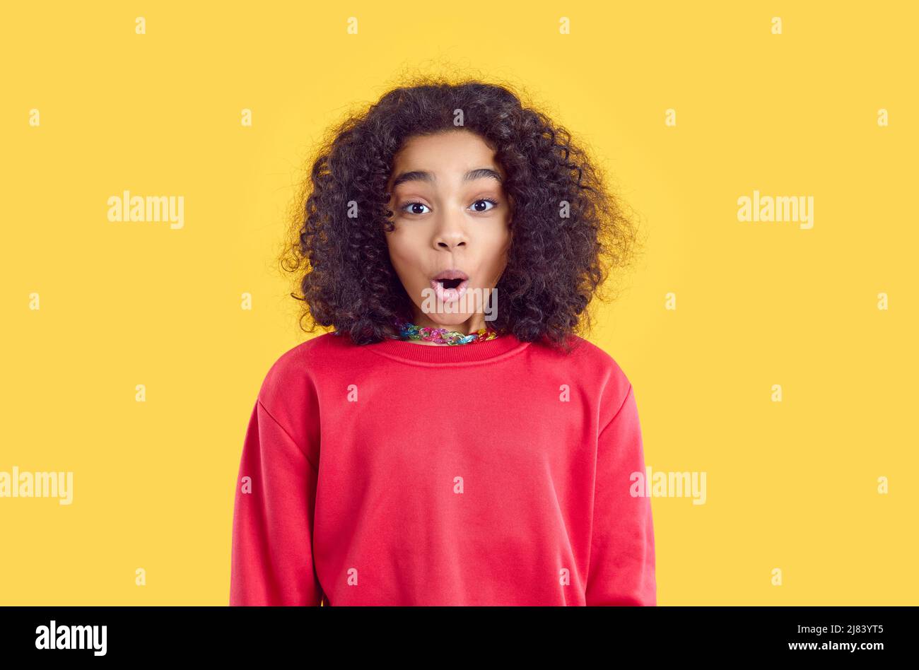 Dunkelhäutig Teenager-Mädchen mit lustig überrascht und schockiert Gesichtsausdruck auf gelbem Hintergrund. Stockfoto