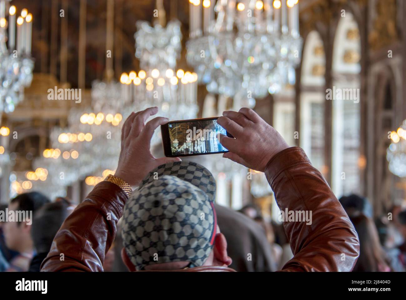 Tourist fotografiert mit einem Smartphone im Spiegelsaal des Schlosses Versailles Stockfoto