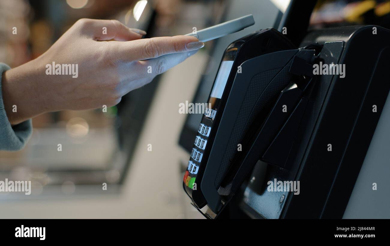 Details weibliche Hände zahlen mit Telefon Kauf per Handy elektronische Zahlungsmaschine Kartenleser E-Geld-Konzept. Kundin bezahlt Smartphone. Pos. Stockfoto