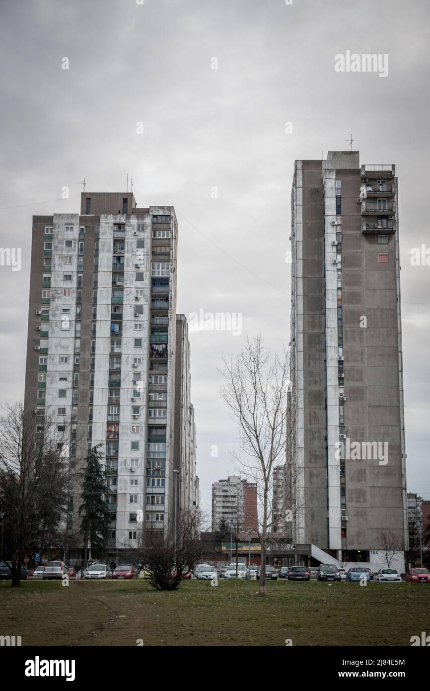 Bild der sozialistischen Gebäude von Novi Beograd in Blok 61 in Belgrad, Serbien mit vorbeifahrenden Autos und Menschen. Sie sind typisch für die kommunistischen Archi Stockfoto