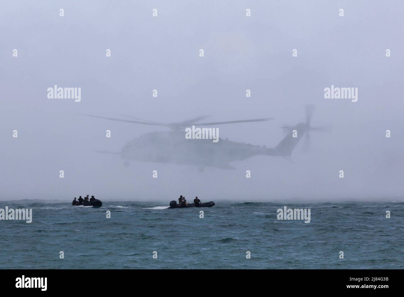 Apr 26, 2022 - Camp Hansen, Okinawa, Japan - US-Marines mit dem Bataillon Landing Team 1/5, 31. Marine Expeditionary Unit (MEU), Manöver auf Gummi-Raiding-Kampfflugzeuge (CRRC) während einer Helocast-Übung in Kin Blue, Okinawa, Japan, 27. April 2022. Helokasting ist eine Helikopter-Einführungstechnik zum Positionieren und Schweben über Wasser für Marines, aus dem sie springen können. Die 31. MEU, die einzige kontinuierlich im Vorlauf eingesetzte MEU des Marine Corps, stellt eine flexible und tödliche Truppe bereit, die als führende Krisenreaktionstruppe in der Indo-Pazifik-Region eine breite Palette von Militäroperationen durchführen kann. (Credit Ima Stockfoto