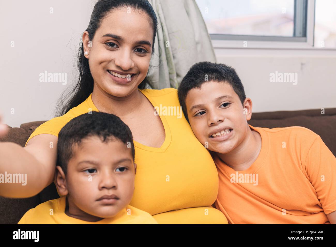 Mama fotografiert ihre Kinder mit dem Handy Stockfoto