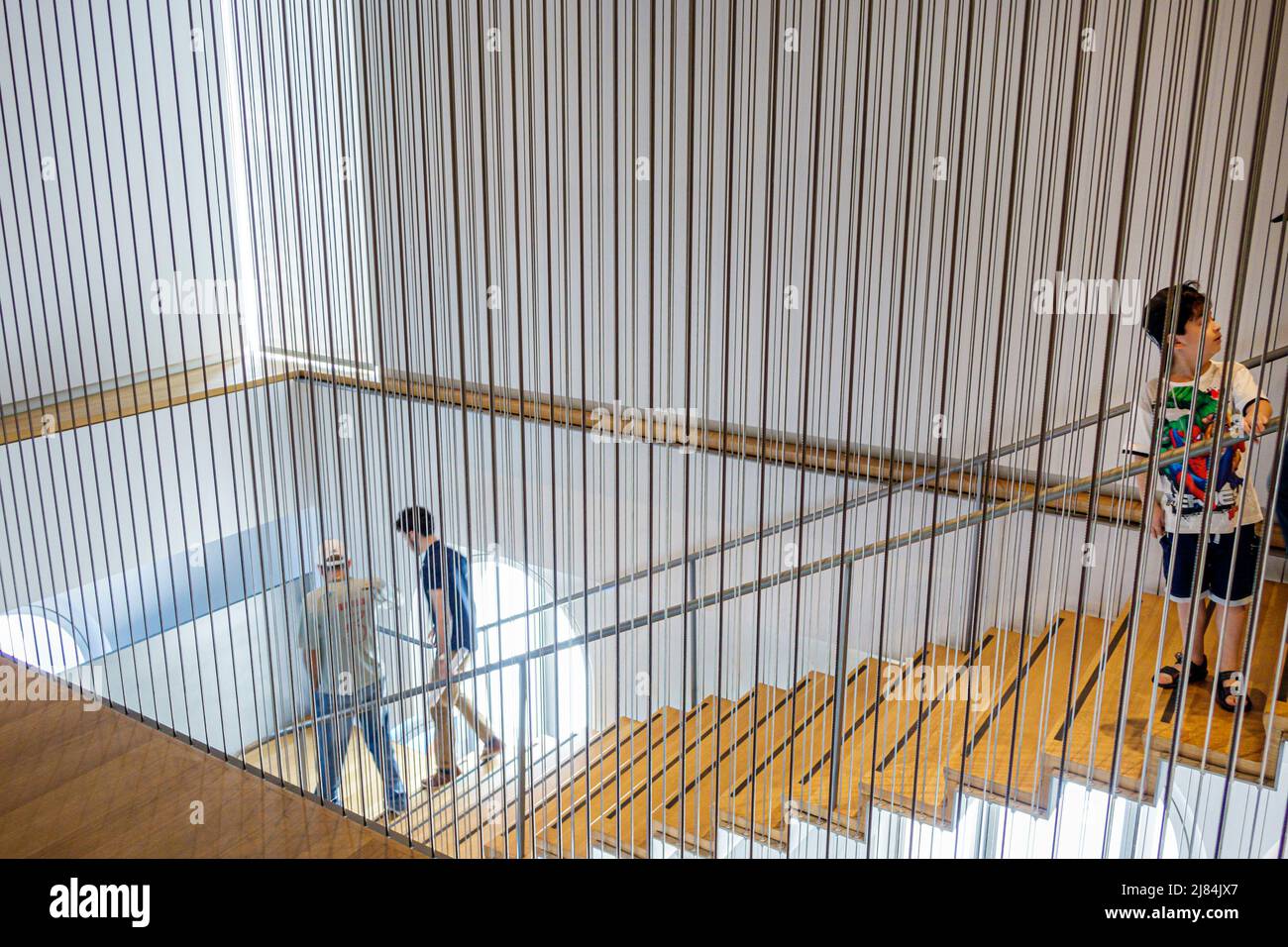 New York City, NYC Manhattan, Columbus Circle, Museum of Arts and Design, MAD, Jerome und Simona Chazen Gebäude Hängetreppe Junge in Besuchern Stockfoto