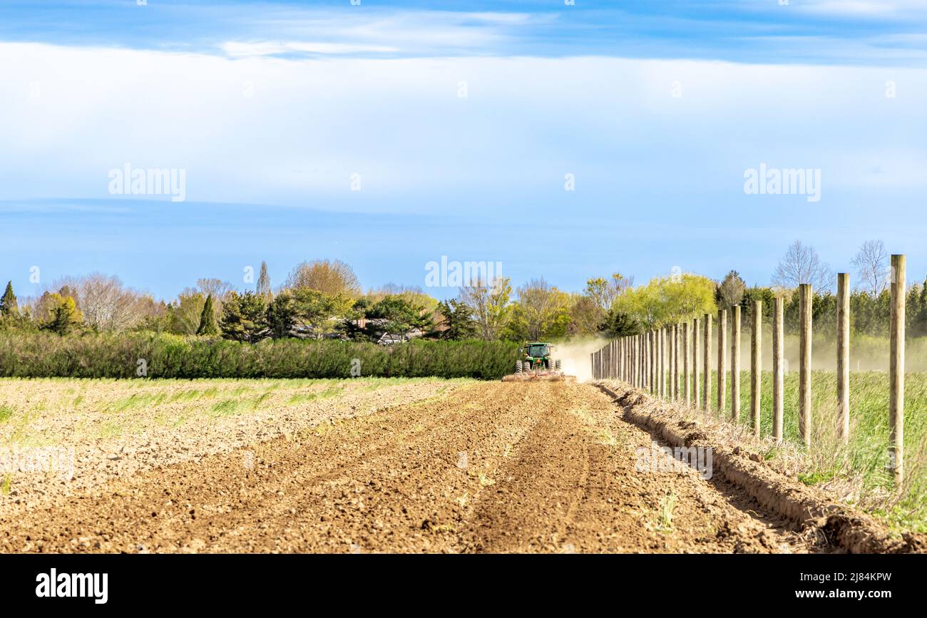 Große grüne john deere pflügt ein staubiges Feld in Wainscott Stockfoto