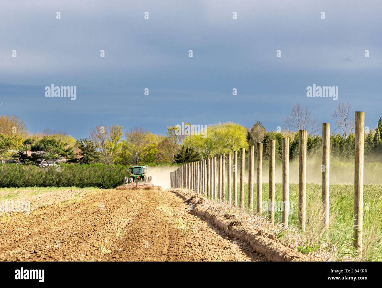 Große grüne john deere pflügt ein staubiges Feld in Wainscott Stockfoto