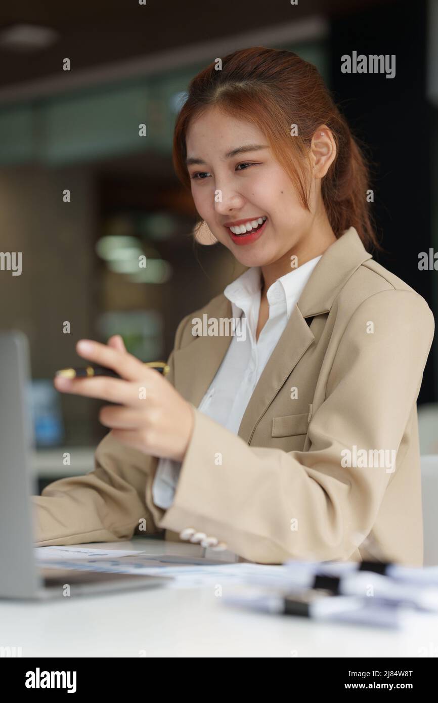 Charmante asiatische Geschäftsfrau im Gespräch mit dem Kunden per Videoanruf. Finanz- und Immobilienmakler Konzept. Stockfoto
