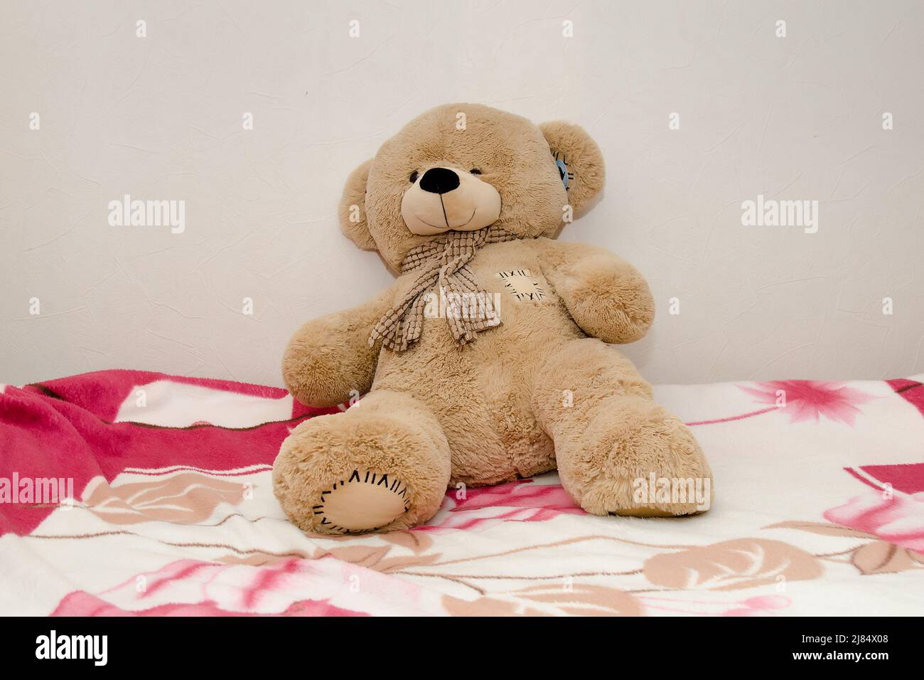 Einsamer Teddybär sitzt auf dem Bett Stockfoto